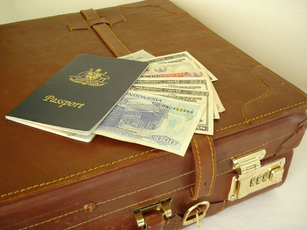 Vintage suitcase, passport, and international cash
